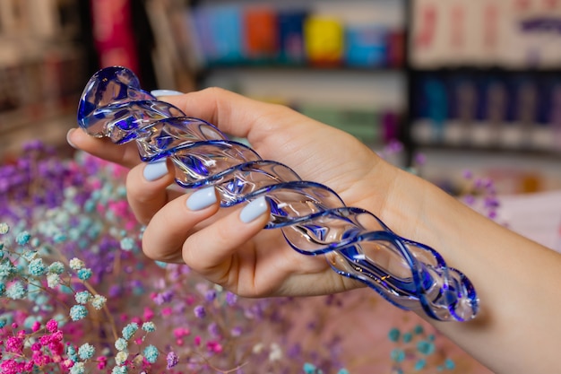 Analer Analplug aus Glas mit flauschigem Schwanz mit weiblichen Händen. Spielzeug für Spiele für Erwachsene.