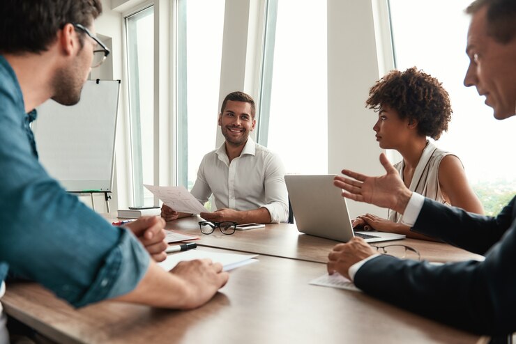 Foto analisando os resultados, jovem com roupa formal, segurando relatórios financeiros e discutindo-os com a equipe
