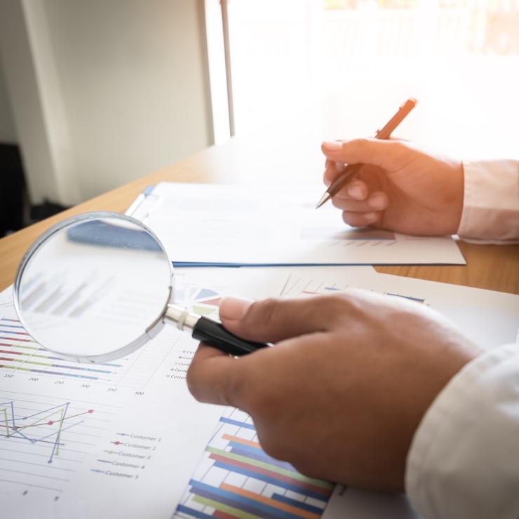 Foto análise de dados no mercado forex com lupa, caneta e calculadora: os gráficos e informações resumidas em papel. gráficos de instrumentos financeiros para análise técnica.