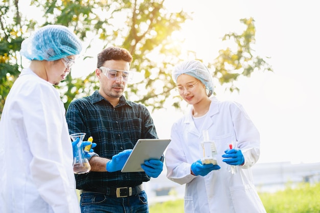 Análisis de científicos biólogos con tableta digital sobre cuestiones ambientales en el polígono industrial