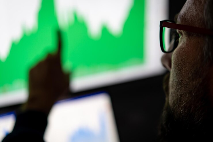 Foto analista de investidor de comerciante de criptografia olhando para a tela do computador analisando dados do gráfico financeiro no monitor do pc, pensando em riscos globais de investimento no mercado de bolsa de valores on-line, visão por cima do ombro.