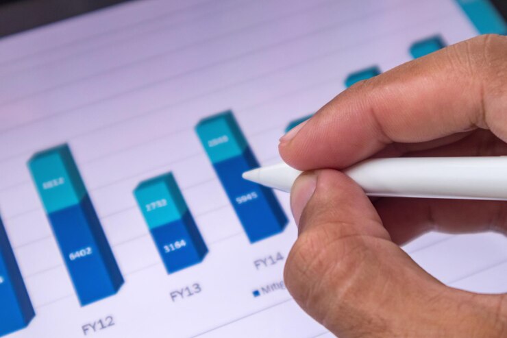 Foto analista señalando un gráfico de crecimiento de los datos financieros de las empresas en una pantalla digital