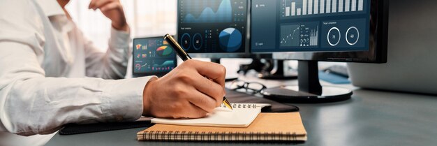 Analista trabajando en análisis de datos o panel de BI en monitor de computadora Empresario analizando datos financieros de Fintech en la oficina corporativa para marketing empresarial y planificación estratégica Trailblazing