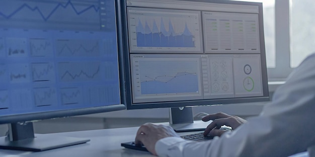 Un analista utiliza una computadora y un tablero de control para el análisis de datos comerciales y el sistema de gestión de datos con