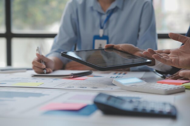 Analistas financeiros analisam relatórios financeiros de negócios em um projeto de investimento de planejamento de tablet digital durante uma discussão em uma reunião corporativa mostrando os resultados de seu trabalho em equipe bem-sucedido