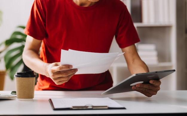 Los analistas financieros analizan los informes financieros de negocios en un proyecto de inversión de planificación de tabletas digitales durante una discusión en una reunión de empresas que muestran los resultados de su exitoso trabajo en equipo