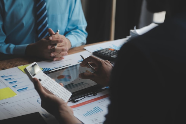 Los analistas financieros analizan los informes financieros de negocios en un proyecto de inversión de planificación de tabletas digitales durante una discusión en una reunión de empresas que muestran los resultados de su exitoso trabajo en equipo