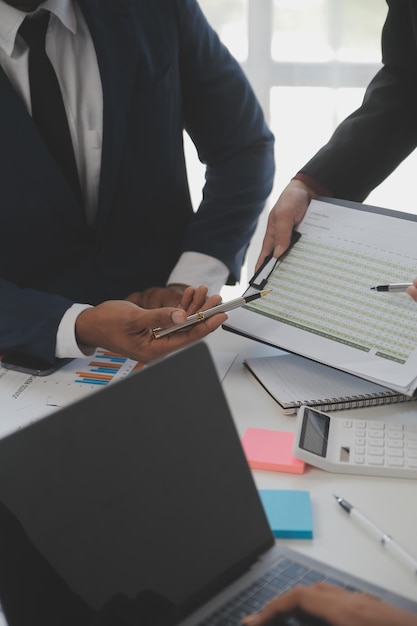 Los analistas financieros analizan informes financieros de negocios sobre un proyecto de inversión de planificación de tabletas digitales durante una discusión en una reunión corporativa que muestra los resultados de su exitoso trabajo en equipo