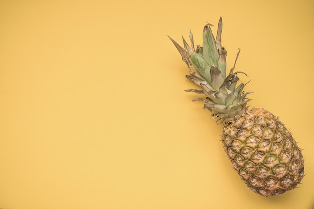 Ananas auf einem hellen gelben Hintergrund. Speicherplatz kopieren. Draufsicht.