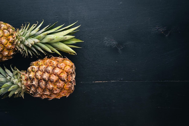 Ananas auf einem hölzernen Hintergrund Ansicht von oben Freier Platz für Text