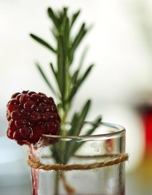 Ananas-Brombeer-Cocktail in Schüssen mit einer Beilage aus gefrorenen Brombeeren und einem Rosmarinzweig