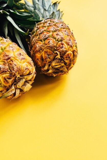 Foto ananas frescos y maduros de fondo amarillo