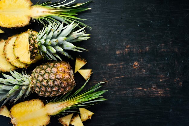 Ananas. Geschnittene Ananas auf einem hölzernen Hintergrund. Ansicht von oben. Freier Kopienraum.