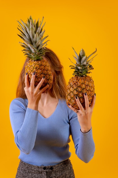 Ananas halbieren gelben Hintergrund hinter einer Frau, die ihn hält