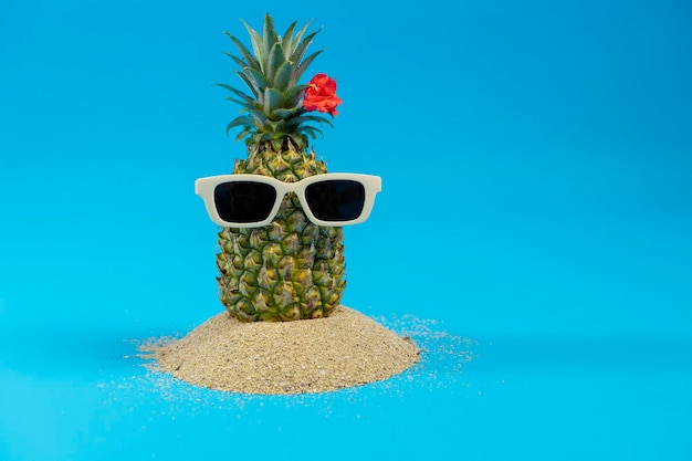 Ananas in einer Sonnenbrille auf weißem Hintergrund