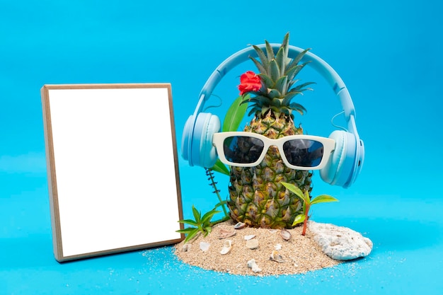 Ananas in einer Sonnenbrille und einem Mockup-Board auf weißem Hintergrund