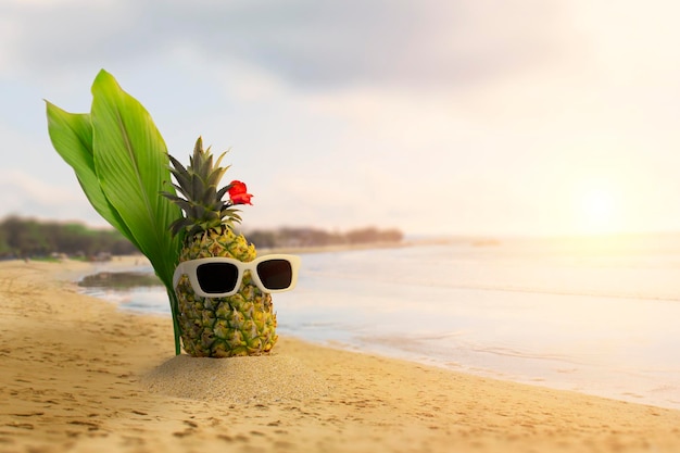 Foto ananas mit sonnenbrille und kopfhörern am tropischen strand