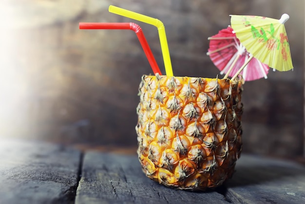 Foto ananas mit strohhalm und cocktailregenschirm