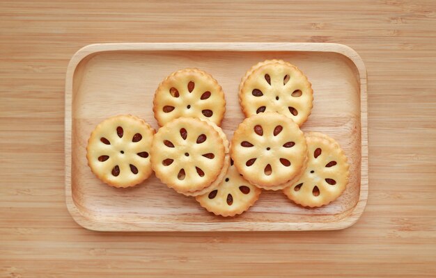 Ananas-Plätzchen auf hölzernem Behälter gegen Hintergrund des hölzernen Brettes. Thailändisches Snack Food.