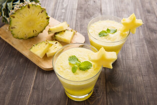 Ananas Smoothie mit frischer Ananas auf Holztisch