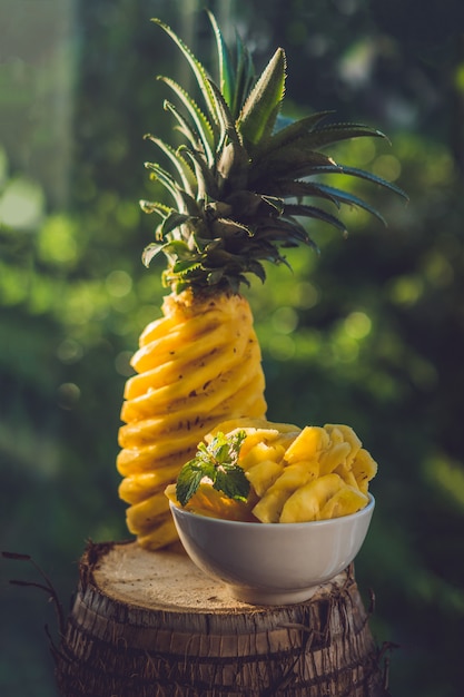 Ananas und Ananasscheiben auf einem Hintergrund des Grüns