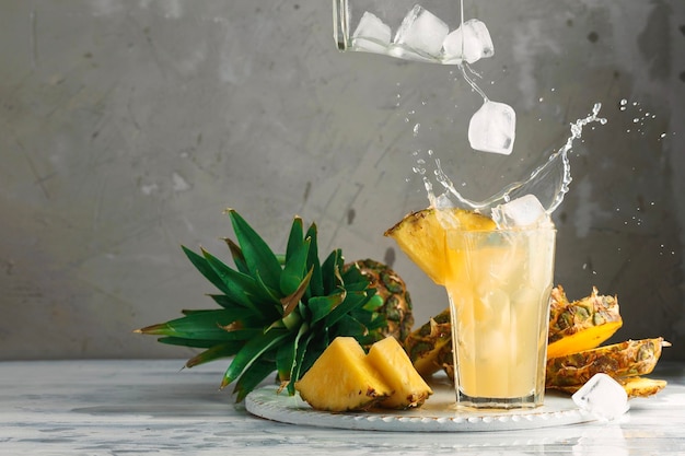 Ananas und Eis mit Spritzer auf Holz