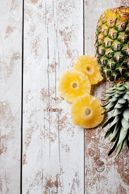 Foto ananas und getrocknete ananasringe auf holz