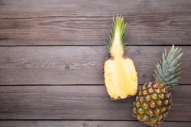 Ananas und Hälfte der Ananas auf einem grauen Hintergrund