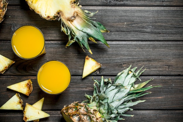 Foto ananassaft in einem glas und duftende ananasstücke