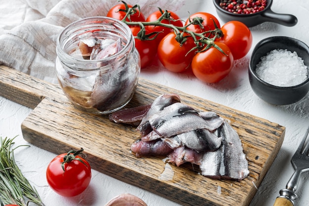 Anchoa en escabeche, sobre tabla de cortar de madera, en blanco