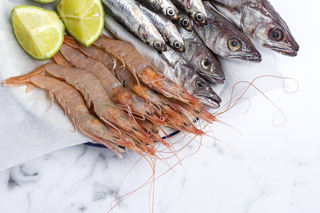 Anchovas, camarões e badejo cru preparados para fritar