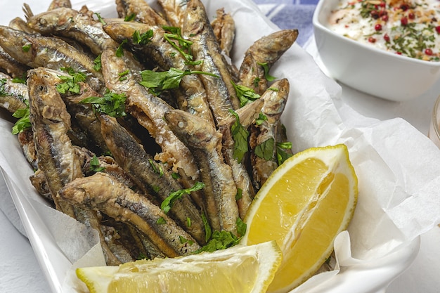 Anchovas fritas tradicionais com limão e salsa. conceito de frutos do mar