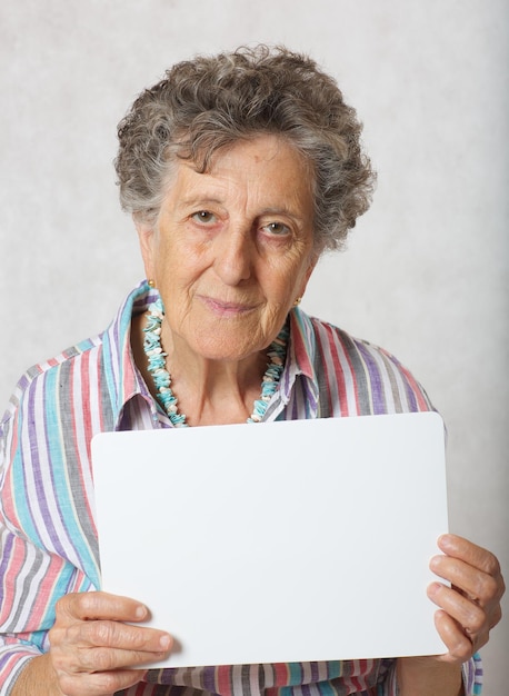 Anciana de entre 70 y 80 años con un papel. Espacio libre para un texto