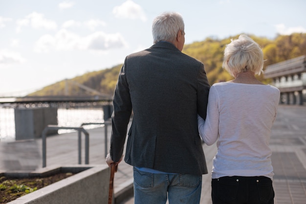 Anciana agradable pareja alegre manteniendo juntos relajándose y disfrutando del fin de semana