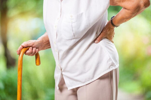 Anciana al aire libre con dolor de espalda