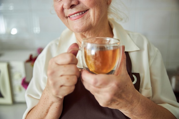 Anciana alegre sosteniendo una taza de té