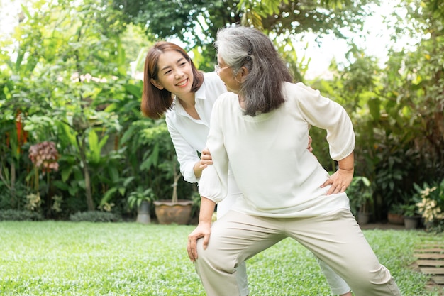 Una anciana anciana asiática y ejercicio en el patio trasero con su hija