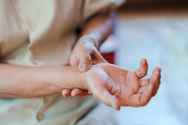 Una anciana apretando su muñeca debido al dolor Concepto de problemas de salud en los ancianos