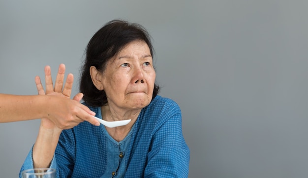 Anciana asiática aburrida con la comida