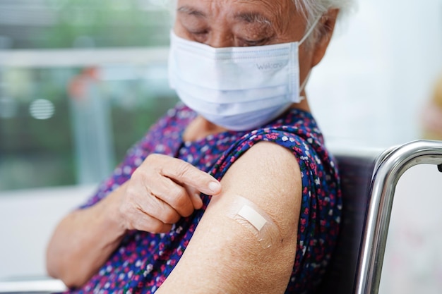 Anciana asiática anciana recibiendo la vacuna para proteger el virus de la corona