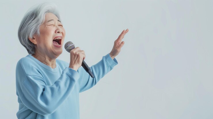 Una anciana asiática cantando un karaoke feliz como una actividad de relajación