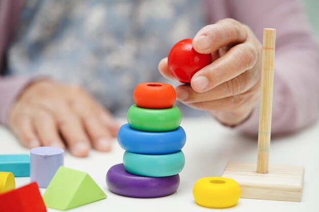 Foto anciana asiática jugando rompecabezas para practicar el entrenamiento cerebral para la prevención de la demencia enfermedad de alzheimer