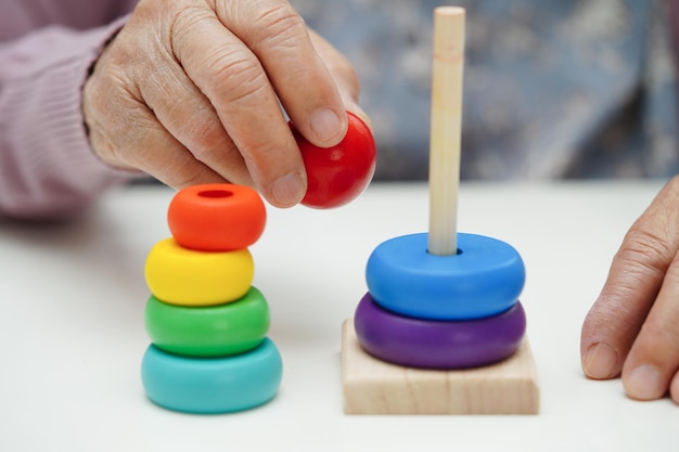 Anciana asiática jugando rompecabezas para practicar el entrenamiento cerebral para la prevención de la demencia