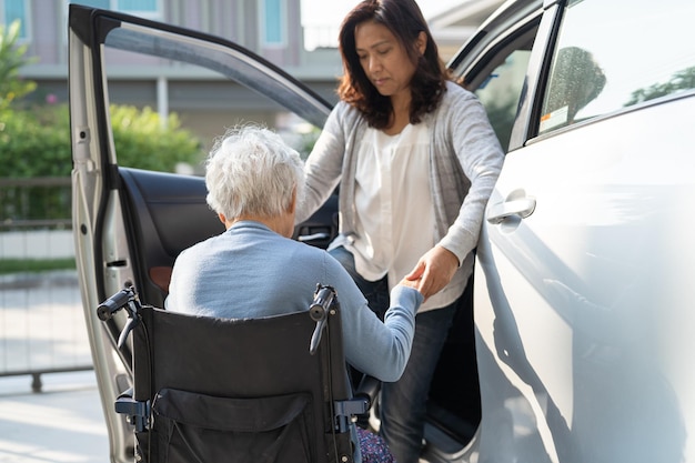 Una anciana asiática o una anciana paciente sentada en silla de ruedas se prepara para llegar a su automóvil concepto médico fuerte y saludable