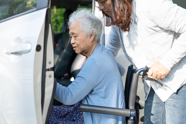 Una anciana asiática o una anciana paciente sentada en silla de ruedas se prepara para llegar a su automóvil concepto médico fuerte y saludable