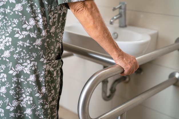 Anciana asiática paciente usa baño baño manejar seguridad en hospital de enfermería concepto médico fuerte y saludable