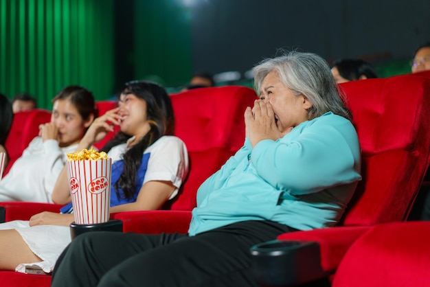 Foto una anciana asiática sorprendida por una película de terror en el cine