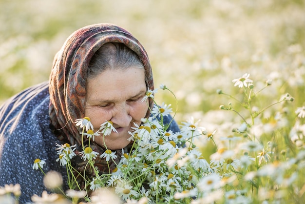 Anciana en un campo con margaritas Retrato de verano