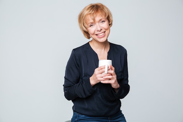 Anciana complacida sosteniendo una taza de té