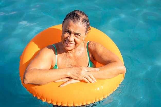 Anciana disfrutando de sus vacaciones en la piscina del hotel